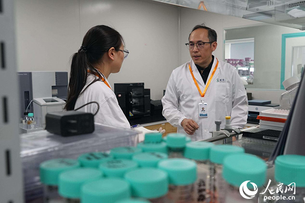 徐剛博士在實(shí)驗(yàn)室與工作人員交流。人民網(wǎng)記者 郝帥攝