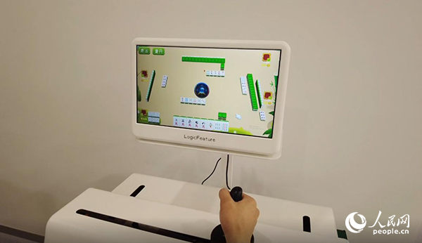 工作人員正在演示“運(yùn)動(dòng)-認(rèn)知康復(fù)機(jī)器人”。人民網(wǎng)記者 郝帥攝